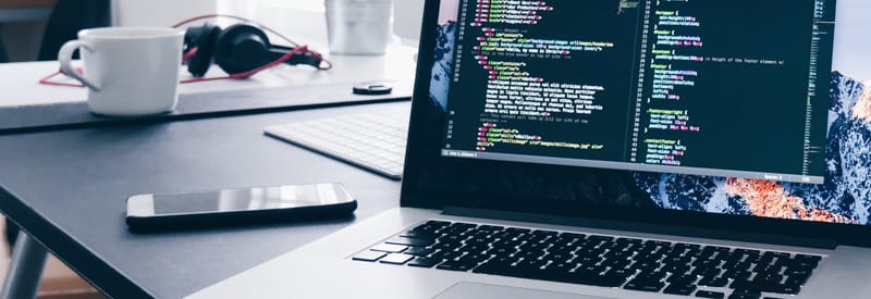 Photo of computer open with code displayed